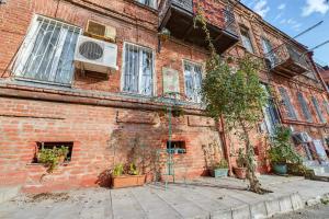 a brick building with potted plants in front of it at House 52 Boutique Hotel in Tbilisi City