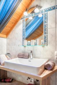 een badkamer met een witte wastafel en een spiegel bij Bergchalet am Tonimörtlhof in Mariapfarr