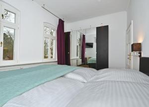 ヘリングスドルフにあるHohe Buchen Apartment 1の窓付きのベッドルームに大きな白いベッド1台が備わります。