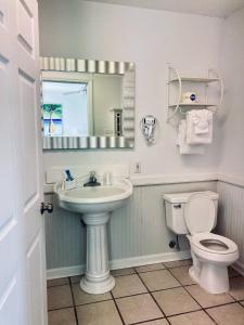 uma casa de banho com um lavatório, um WC e um espelho. em Waterway Inn em Cedar Point