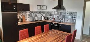 a kitchen with a wooden table and red chairs at Les gîtes de la commanderie de Saint Jean SCAFER in Beynat