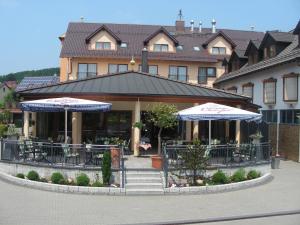 um restaurante com mesas e guarda-sóis em frente a um edifício em Hotel Jägerhof em Weibersbrunn