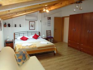 a bedroom with a large bed with red pillows at Apartments Sanja in Baška