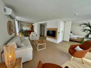 uma sala de estar com um sofá branco e um quarto com uma cama em Hotel Emblemático Hi Suites em Santa Cruz de Tenerife