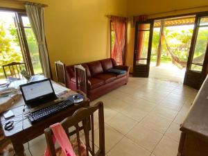 un soggiorno con tavolo e computer portatile di Chalé de Praia em Condomínio Jacumã Beach & Golf Village - pé na areia a Jacumã - Conde