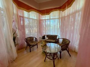 ein Esszimmer mit einem Tisch, Stühlen und einem Fenster in der Unterkunft Moskvа Hotel in Aluschta