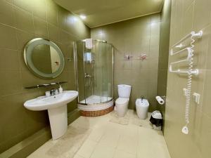 ein Bad mit einem Waschbecken, einem WC und einer Dusche in der Unterkunft Moskvа Hotel in Aluschta