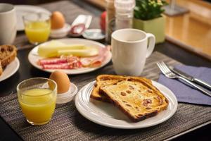 a table with plates of toast and eggs and orange juice at Holiday Inn Gent Expo, an IHG Hotel in Ghent