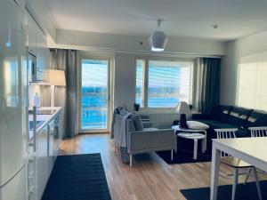 a living room with a couch and a table and a kitchen at STAY Matinkylä Apartments in Espoo