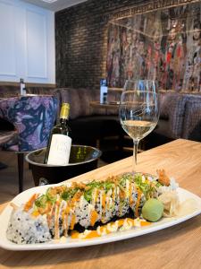 einen Teller mit Essen und ein Glas Wein auf dem Tisch in der Unterkunft Boutique Hotel Jersey in Goes