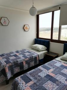 a room with two beds and a window at Eluchans Plaza 2 in Viña del Mar +19 photos