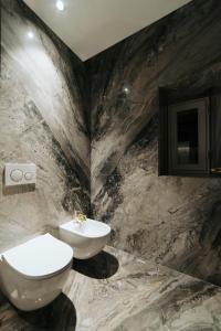 a marble bathroom with a toilet and a sink at Albergo Italia in Matera