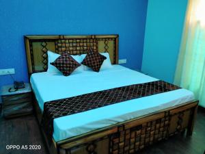 a bedroom with a large bed with blue walls at Oak Retreat Huts in Shimla