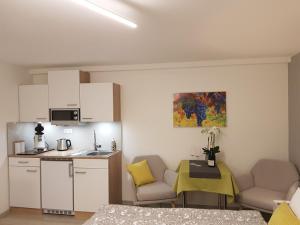 een kleine keuken met een tafel en stoelen in een kamer bij Gästezimmer-Apartment Heidi Hönl in Buergstadt
