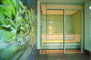 バート・メルゲントハイムにあるHotel Alexaのベッドルームにつながるガラスドア付きの部屋