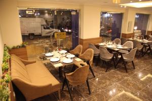 Jewel Agouza Hotel في القاهرة: مطعم فيه طاولات وكراسي في الغرفة