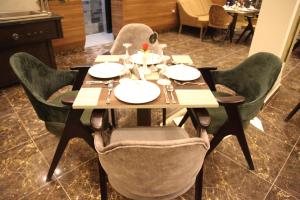 Jewel Agouza Hotel في القاهرة: طاولة في مطعم عليه كراسي وصحون