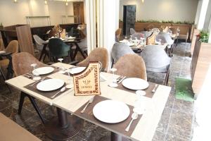 Jewel Agouza Hotel في القاهرة: غرفة طعام مع طاولات وكراسي في مطعم