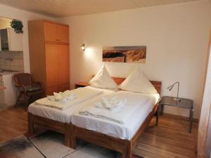 una camera da letto con letto, lenzuola e cuscini bianchi di Apart-1-OG-Nr2 a Darmstadt