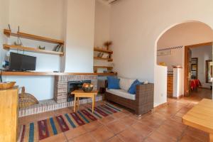 uma sala de estar com um sofá e uma lareira em Casa Chica em Pizarra