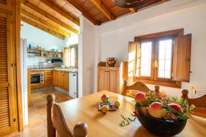eine Küche mit einem Holztisch mit einer Obstschale darauf in der Unterkunft Casa Chica in Pizarra