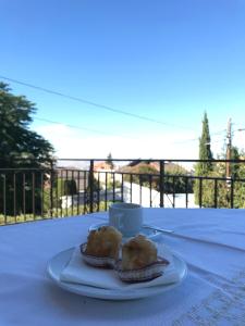 un plato con dos donuts en una mesa con una taza en Villa Jazmín, en Monachil