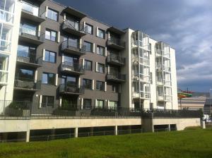 um grande edifício de apartamentos com um campo de relva em frente em Near Ozas em Vilnius