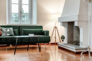 a living room with a green couch and a fireplace at Salorino Apartments by Quokka 360 - with a view of nature in Mendrisio