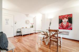 ein Esszimmer mit einem Tisch und einem Gemälde an der Wand in der Unterkunft Salorino Apartments by Quokka 360 - with a view of nature in Mendrisio