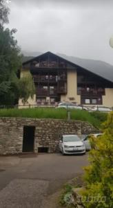 Un coche aparcado en un estacionamiento frente a un edificio. en Residence Hotel 4s Montagna, en Cogolo