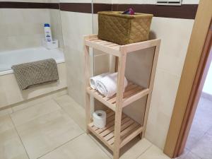 a bathroom with a wooden shelf with towels and a basket at APARTMENT LA CALA DESIGN & ALAMAR SEA WIEW. in La Cala de Mijas +11 photos