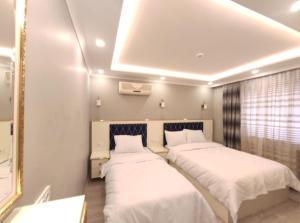 dwa łóżka w pokoju z białą pościelą w obiekcie Family Istanbul Hotel w Stambule