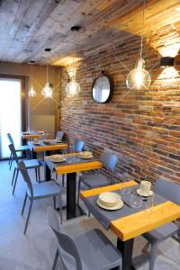 un restaurante con mesas y sillas de madera y una pared de ladrillo en Room4You, en Oulx