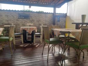a room with tables and chairs and a brick wall at Pousada Sorocotuba - Piscina Aquecida in Guarujá