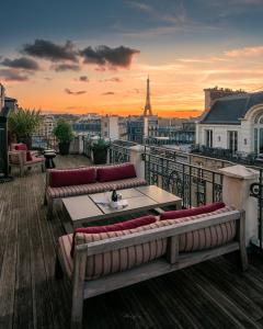 a balcony with couches and a table and a view of the city at Hotel Marignan Champs-Elysées in Paris