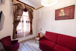 a living room with a red couch and a window at Appartement Maison de L'Église du Couvent in Narbonne