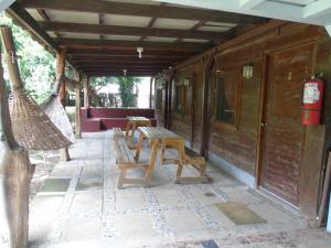 a porch with benches and a table and chairs at Hostal Villas Mexico in San Juan del Sur