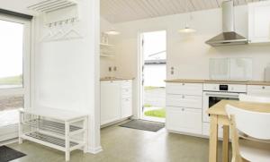 - une cuisine blanche avec des placards blancs et une table dans l'établissement Immaculate 2-Bed House at the beach 12H, à Brenderup