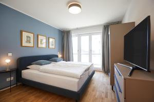 a bedroom with a bed and a flat screen tv at Redlok in Garmisch-Partenkirchen