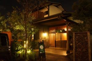 un edificio con un cartel delante de él por la noche en tsukigakireidesune, en Kumamoto