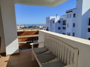 a balcony with two chairs and a view of a city at APARTMENT LA CALA DESIGN & ALAMAR SEA WIEW. in La Cala de Mijas