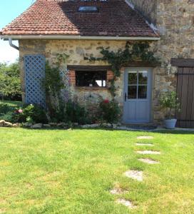 une maison en pierre avec une porte bleue et une cour dans l'établissement Le COSY, à Saint-Yrieix-la-Perche