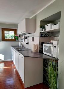 a kitchen with white cabinets and a counter top at STONE in Crodo