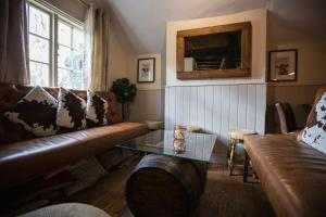 sala de estar con sofá y mesa de cristal en The Bull Inn Pub en Stanford Dingley