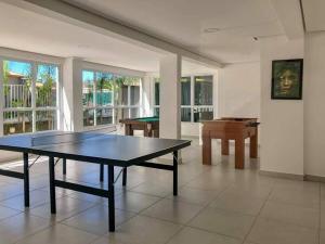 a dining room with a ping pong table and a pool table at PALMEIRAS A14 in Ubatuba