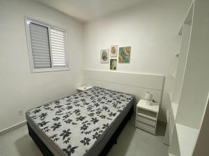 a white bedroom with a bed and a window at PALMEIRAS A14 in Ubatuba +23 photos