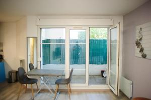 a dining room with a table and chairs and a window at Une bulle de quiétude proche de Paris et Créteil in Bonneuil-sur-Marne