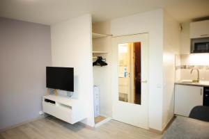 a living room with a tv on a white wall at Une bulle de quiétude proche de Paris et Créteil in Bonneuil-sur-Marne