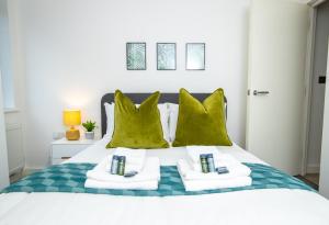 um quarto com uma cama com almofadas verdes em Pembroke House Apartments Exeter For Families Business Relocation Free Parking em Exeter