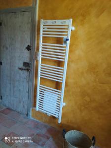 eine weiße Handtuch-Leiter an einer Wand neben einer Tür in der Unterkunft Les Amis de Gaure in Rouffiac-dʼAude